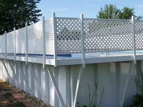 White lattice fence on top of a painted pool wall